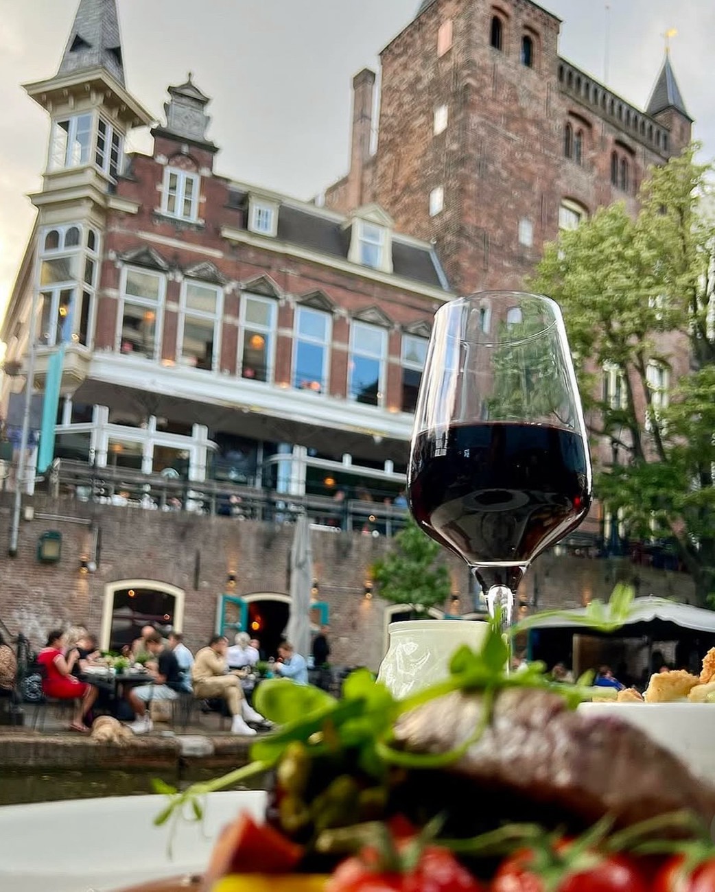 Gasten in de zon op het terras aan de Oudegracht